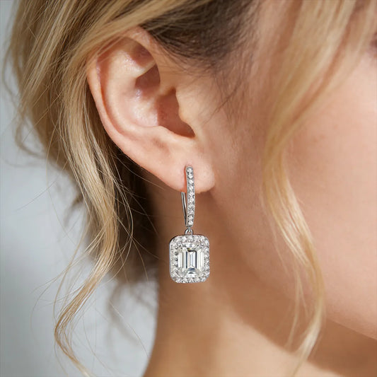 Asymmetric sterling silver bar drop earrings with halo-set baguette stones and pear-cut moissanite accents.