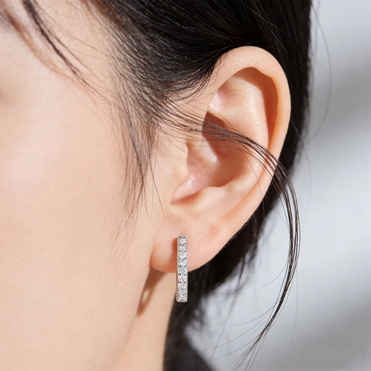 Minimalist sterling silver earrings featuring a slim pavé moissanite bar paired with a half-pavé huggie hoop, offering lightweight, low-profile daily wear.
