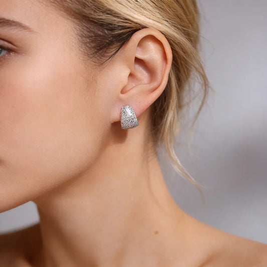 Sterling silver dome cuff stud earrings fully set with 1.5mm moissanite stones, creating a bold, full-pavé statement look with a comfortable curved fit.