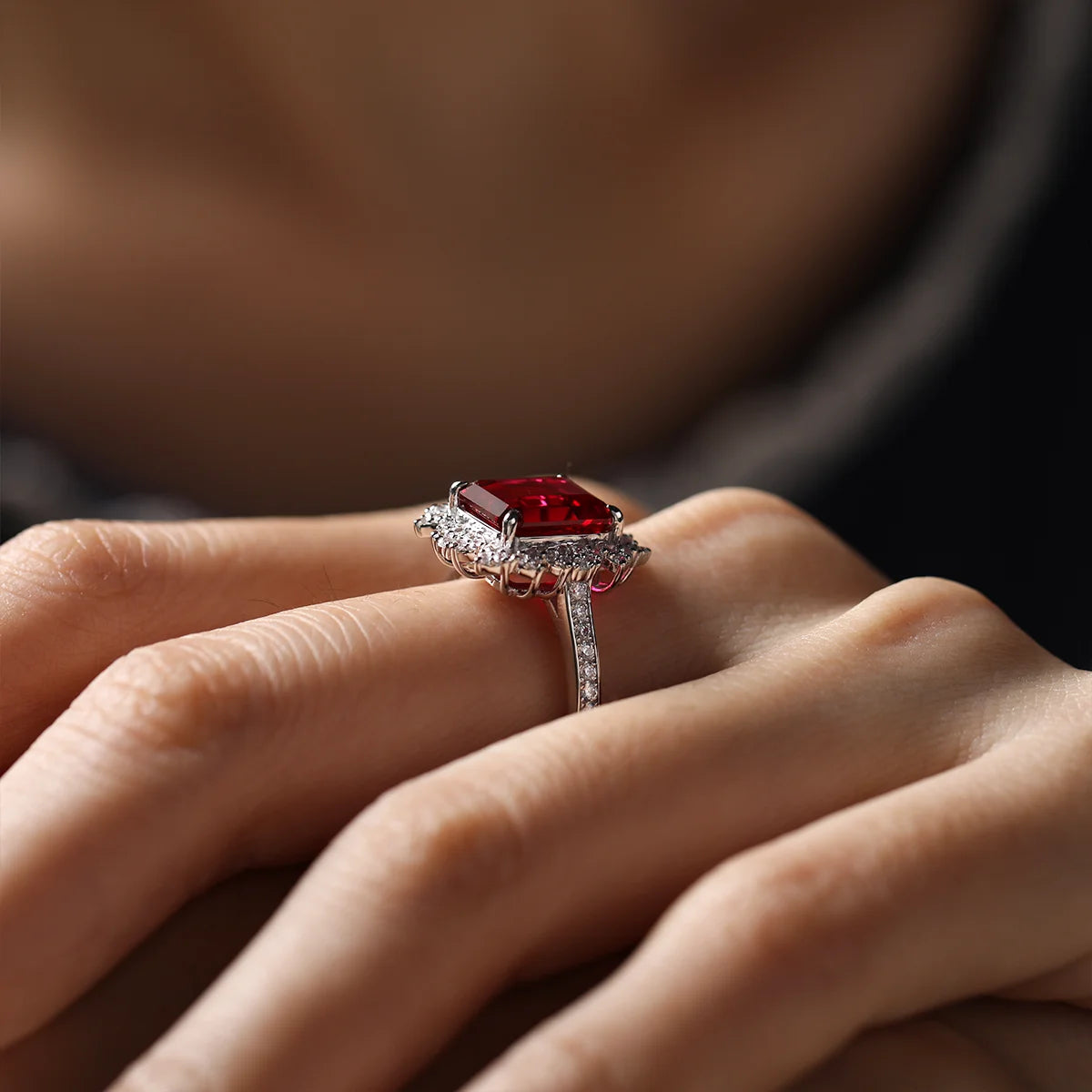 Sterling silver ring set with a 10×8mm, approx. 5.5ct emerald-cut lab-grown ruby and white cubic zirconia accents, offering a fiery, elegant glow.