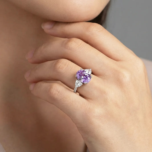 Luminous three-stone engagement ring with 1.8ct oval purple diamond center and pear-shaped white diamond side stones on 14K white gold band