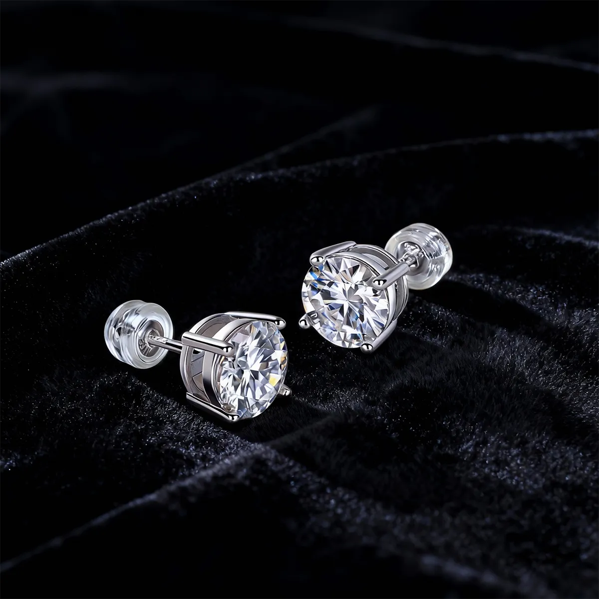 Round cut moissanite stud earrings in four-prong sterling silver setting, 6.5mm hypoallergenic design.