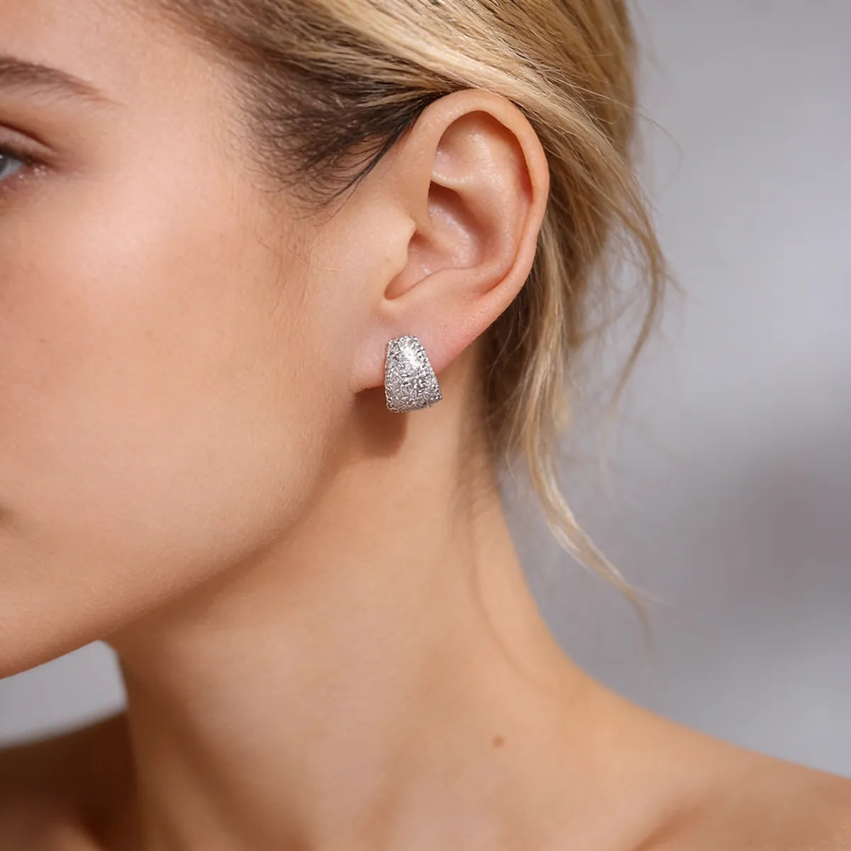 Sterling silver dome cuff stud earrings fully set with 1.5mm moissanite stones, creating a bold, full-pavé statement look with a comfortable curved fit.