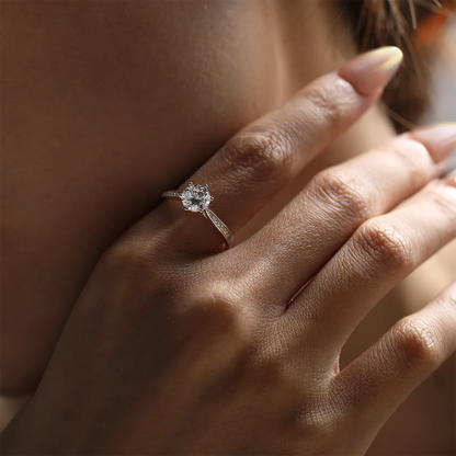 1ct Round Moissanite Heart-Prong Pave Ring in 925 Sterling Silver with 18K White Gold Plating, featuring heart-shaped six prongs and sparkling pave band.