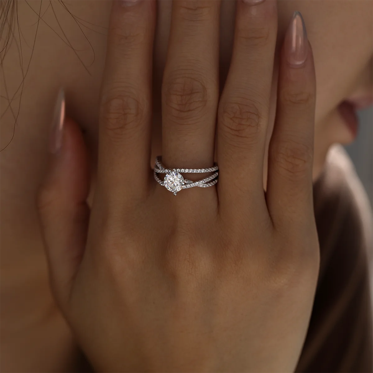 silver moissanite ring with 1ct round center stone and double-row crossover pavé band