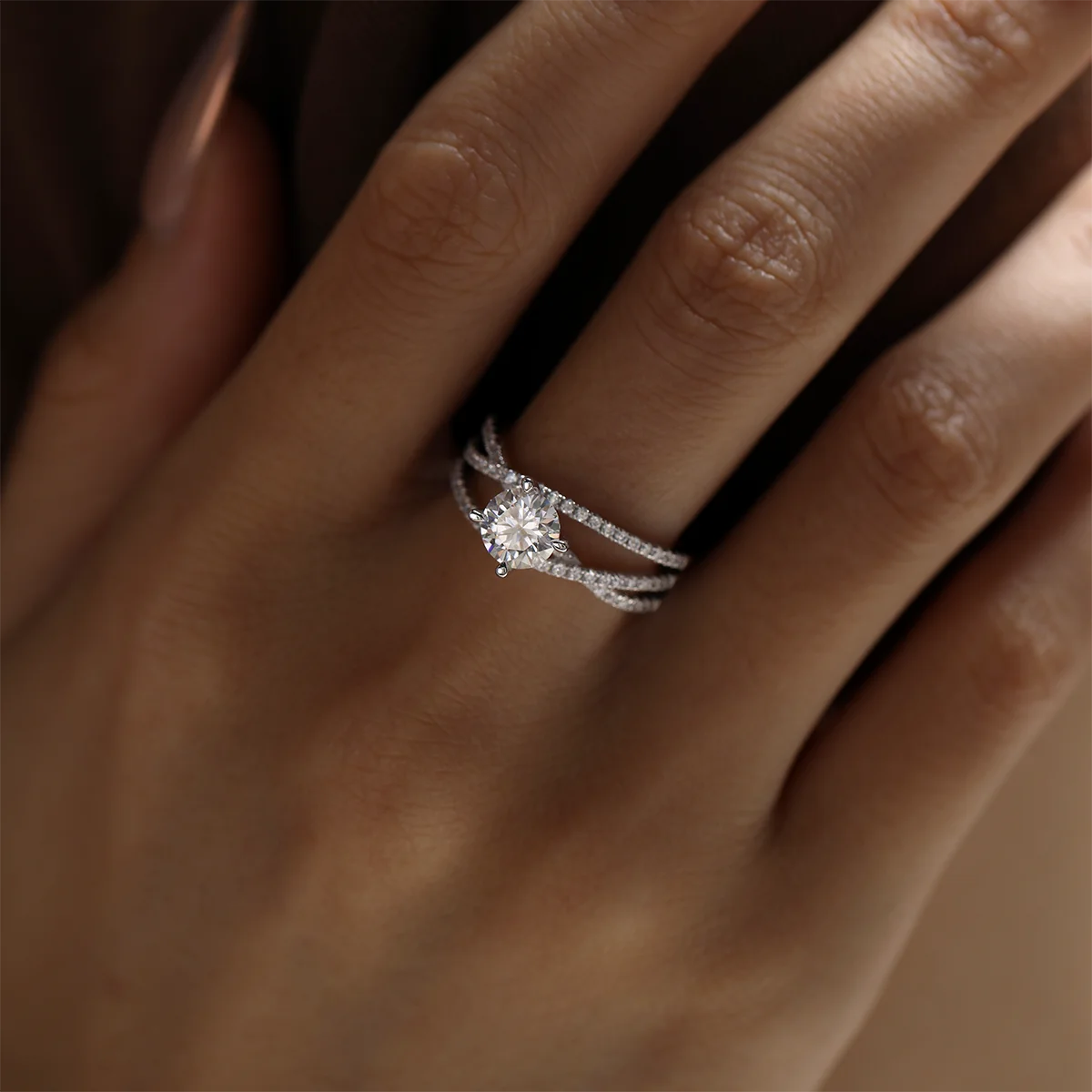 silver moissanite ring with 1ct round center stone and double-row crossover pavé band