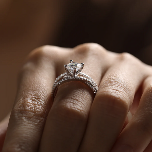 silver moissanite ring with 1ct round center stone and double-row crossover pavé band