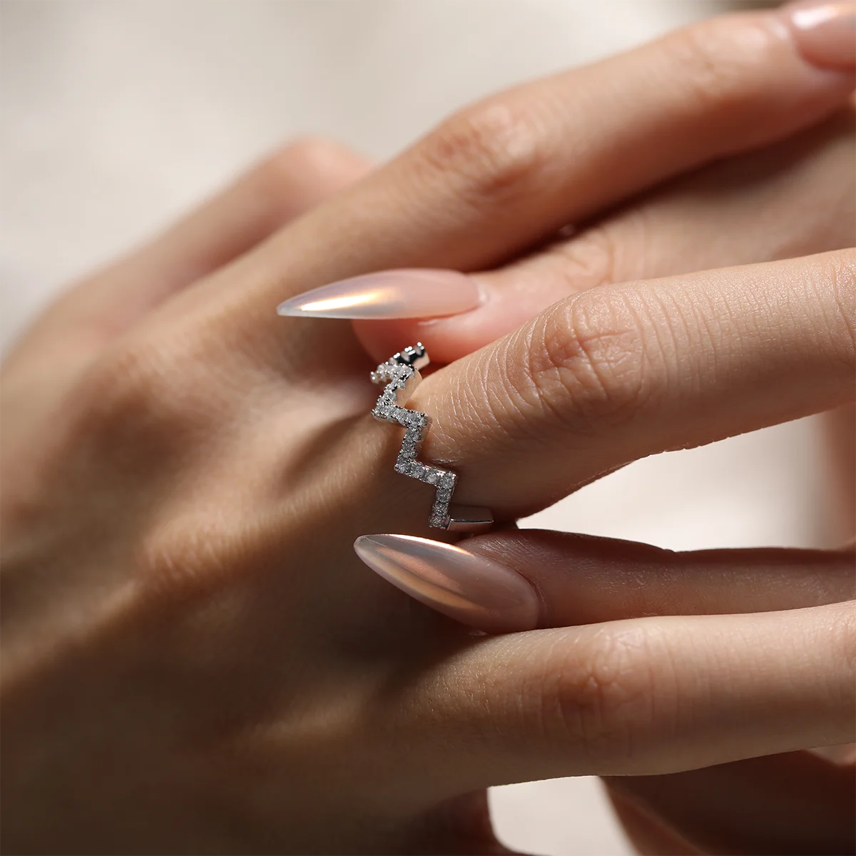 0.7ct Moissanite Geometric Band Ring in 925 Sterling Silver with 18K White Gold Plating, featuring modern folded-line design and sparkling moissanites.