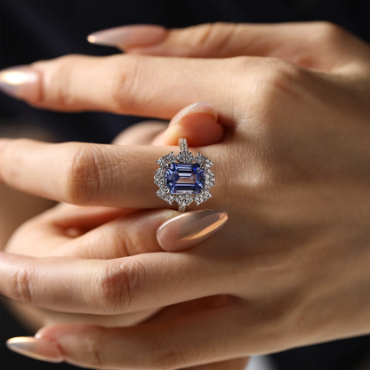 Sterling silver ring set with a 10×8mm, approx. 5.5ct emerald-cut cornflower blue sapphire and white cubic zirconia accents, inspired by a night-sky–themed design.