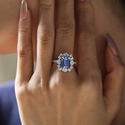 Sterling silver ring set with a 10×8mm, approx. 5.5ct emerald-cut cornflower blue sapphire and white cubic zirconia accents, inspired by a night-sky–themed design.