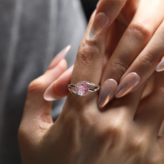 Close-up of the pinkish-orange lab-grown bi-color sapphire with radiant nine-sided facets, reflecting soft peach and coral hues under light