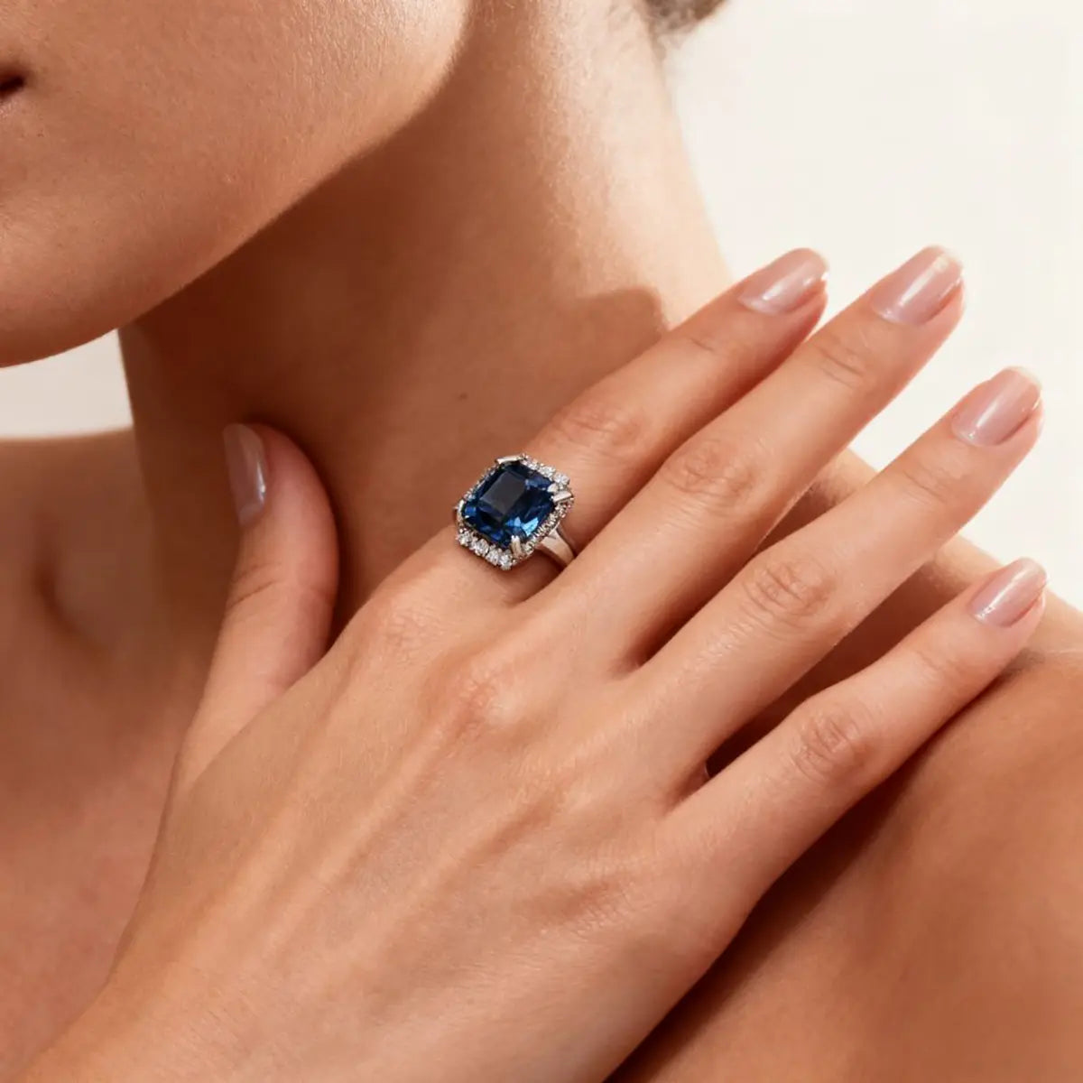 14K white gold ring with a 2.0ct cushion-cut deep blue lab-grown diamond and pavé halo of white diamonds, featuring a simple rounded band.