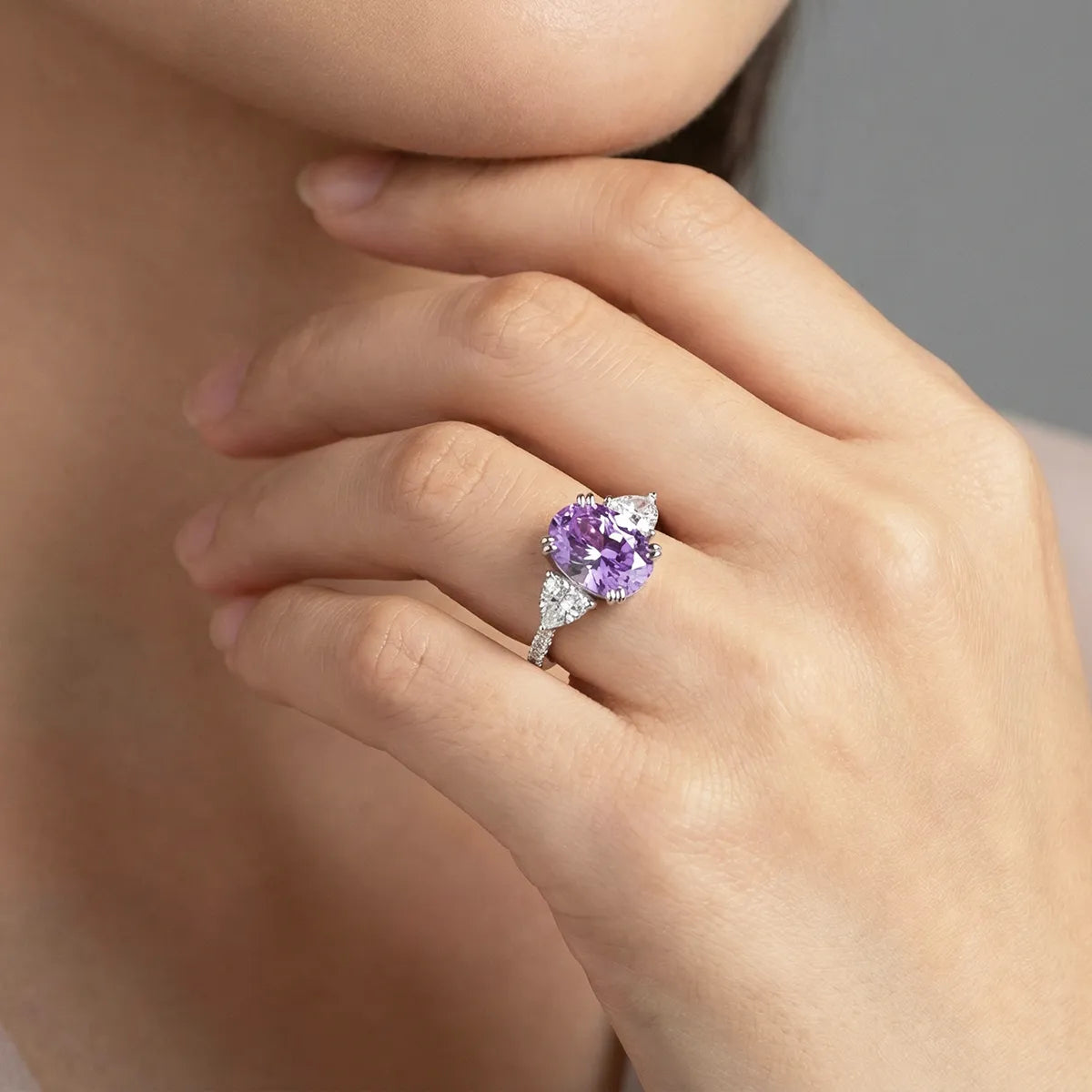 Luminous three-stone engagement ring with 1.8ct oval purple diamond center and pear-shaped white diamond side stones on 14K white gold band