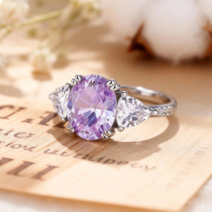 Luminous three-stone engagement ring with 1.8ct oval purple diamond center and pear-shaped white diamond side stones on 14K white gold band