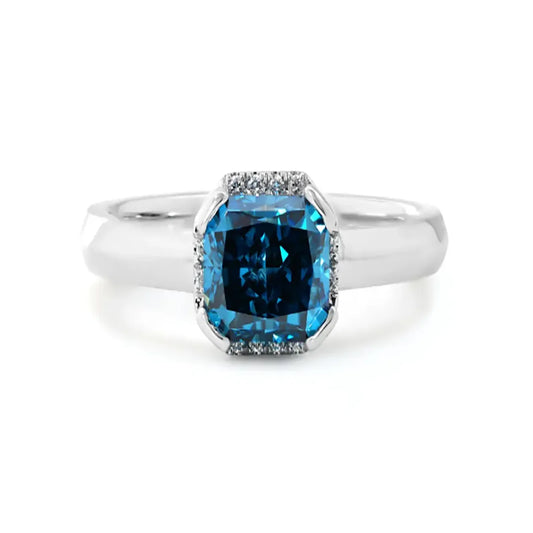 14K white gold ring with a 2.0ct cushion-cut deep blue lab-grown diamond and pavé halo of white diamonds, featuring a simple rounded band.
